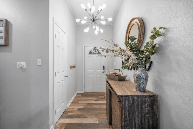 entryway featuring ornamental molding, an inviting chandelier, baseboards, and dark wood-type flooring