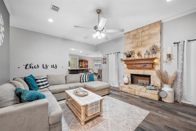 living area with ornamental molding, visible vents, and wood finished floors