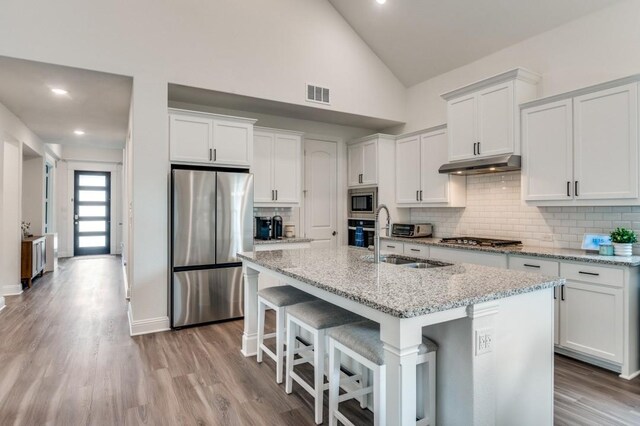 kitchen featuring white cabinets, a sink, appliances with stainless steel finishes, visible vents, and under cabinet range hood