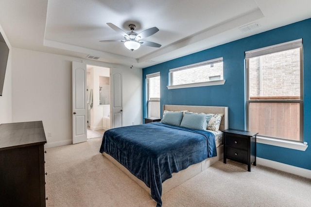 carpeted bedroom with a raised ceiling, visible vents, and baseboards