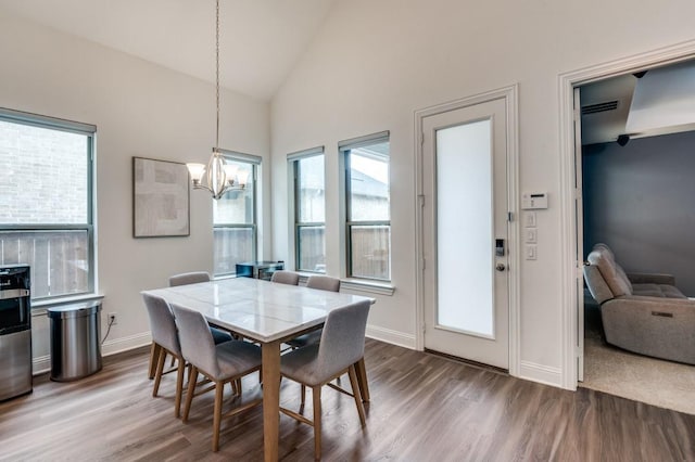 dining space featuring dark wood-style flooring, a chandelier, visible vents, and baseboards