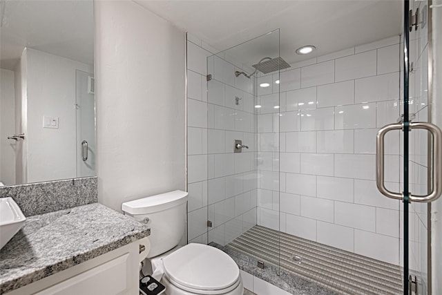 full bath featuring toilet, a stall shower, and vanity