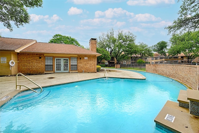 pool featuring fence, a patio, and french doors