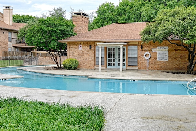 pool with a patio area, french doors, and fence