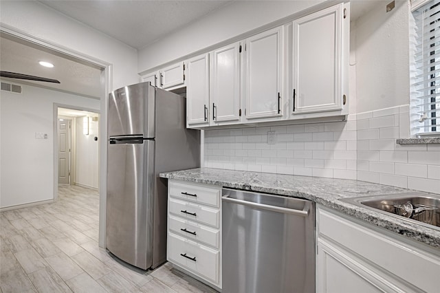 kitchen featuring visible vents, white cabinetry, and stainless steel appliances