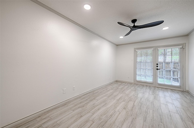 spare room featuring crown molding, ceiling fan, baseboards, and light wood-type flooring