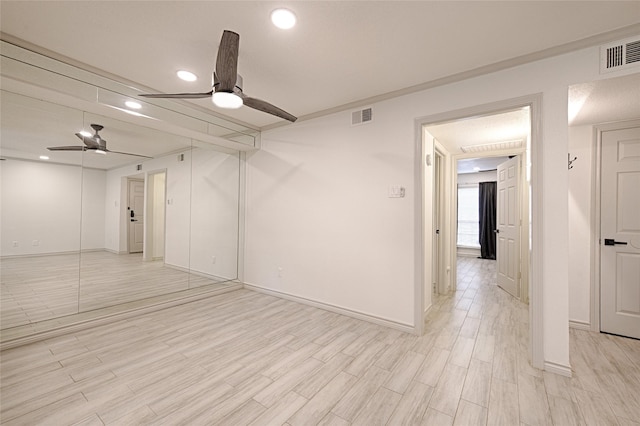 spare room with a ceiling fan, visible vents, and baseboards