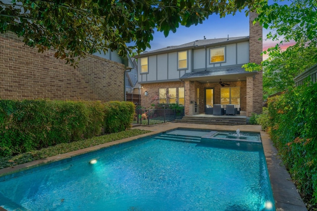 5313 Ridgedale Ave, Dallas, TX 75206 - back of property at dusk with a ceiling fan, an outdoor living space, brick siding, and a pool with connected hot tub