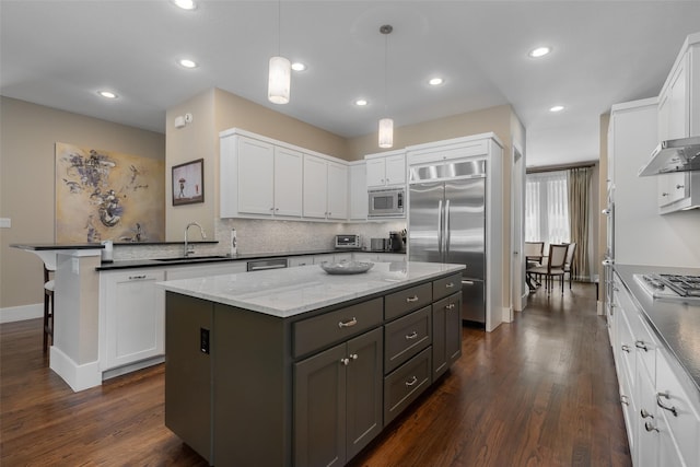 5313 Ridgedale Ave, Dallas, TX 75206 - kitchen with built in appliances, a sink, a kitchen island, white cabinets, and tasteful backsplash