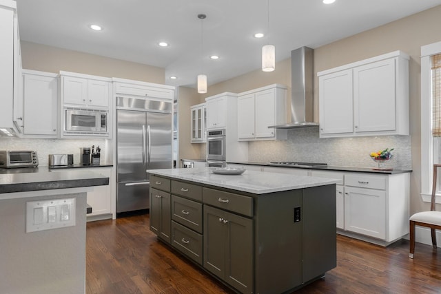 5313 Ridgedale Ave, Dallas, TX 75206 - kitchen featuring built in appliances, wall chimney range hood, backsplash, white cabinets, and a kitchen island