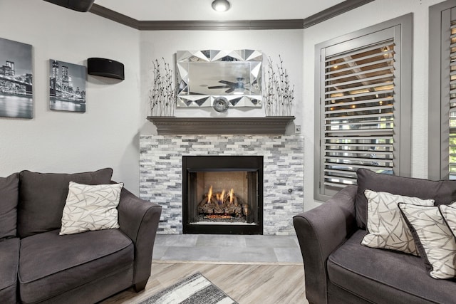 living area with crown molding, wood finished floors, and a fireplace