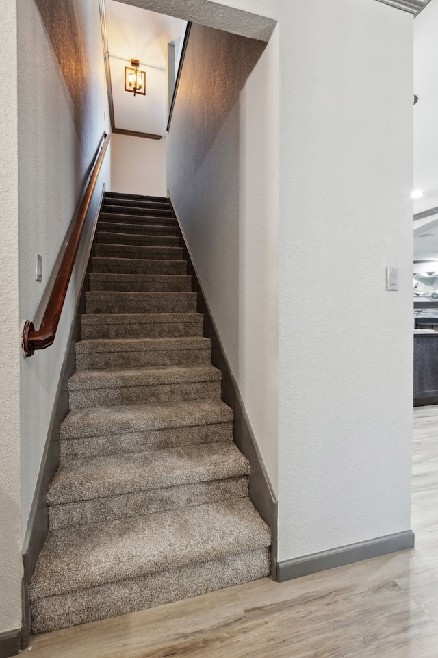 stairway featuring baseboards and wood finished floors