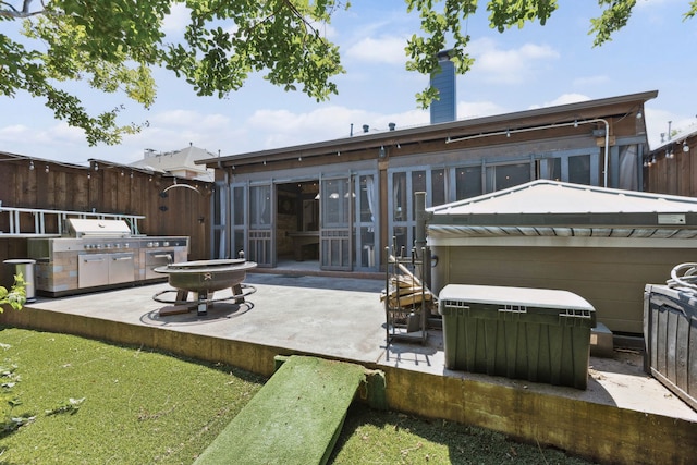 rear view of house featuring fence, a chimney, a gate, a patio area, and a hot tub