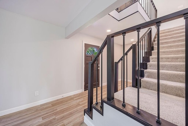 stairway with recessed lighting, wood finished floors, and baseboards