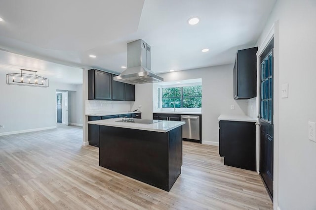 kitchen featuring recessed lighting, stainless steel dishwasher, light countertops, a sink, and island exhaust hood