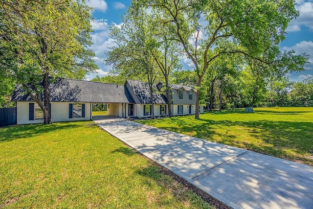cape cod house with a carport, a front lawn, and concrete driveway