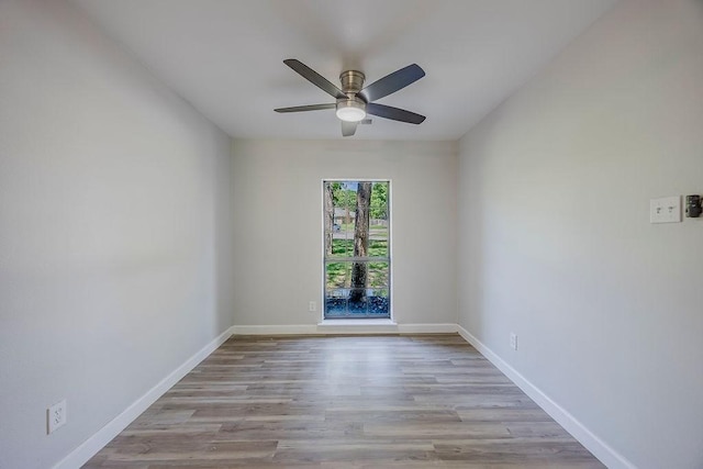 empty room featuring a ceiling fan, wood finished floors, and baseboards