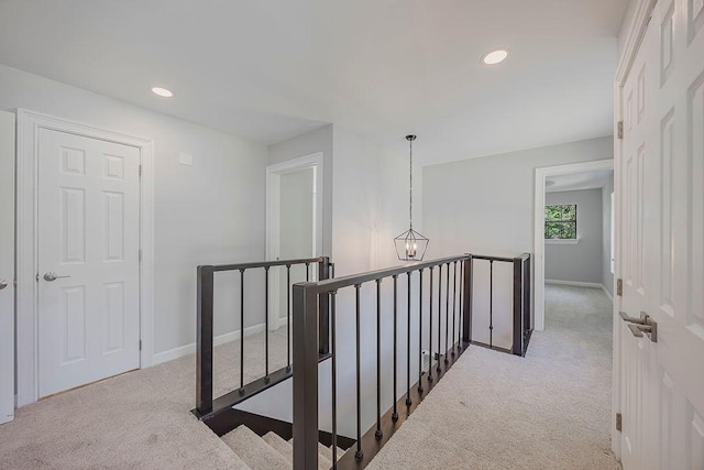 corridor featuring recessed lighting, an upstairs landing, and carpet