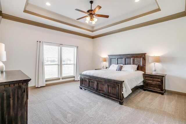 bedroom featuring a raised ceiling, a ceiling fan, carpet, baseboards, and ornamental molding