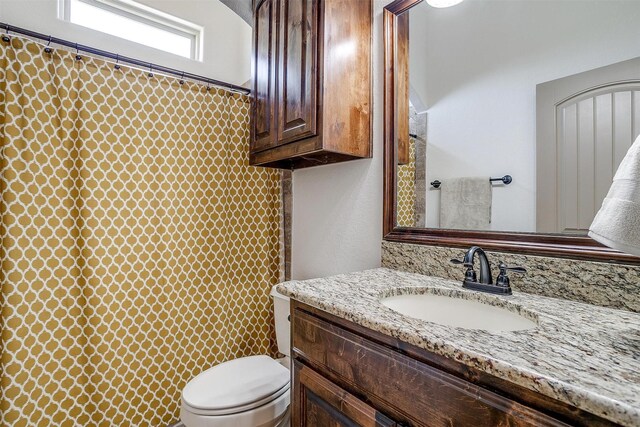 bathroom with a shower with shower curtain, toilet, and vanity
