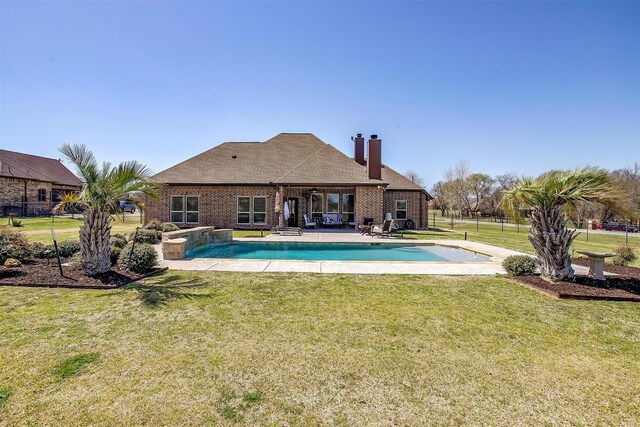 outdoor pool with a yard and a patio