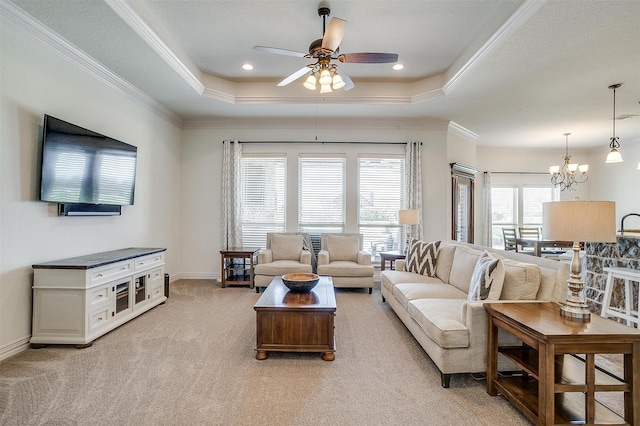 living room with crown molding, light carpet, a raised ceiling, and ceiling fan with notable chandelier