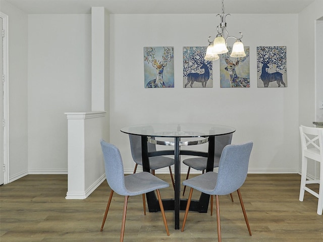 dining space with an inviting chandelier, wood finished floors, and baseboards