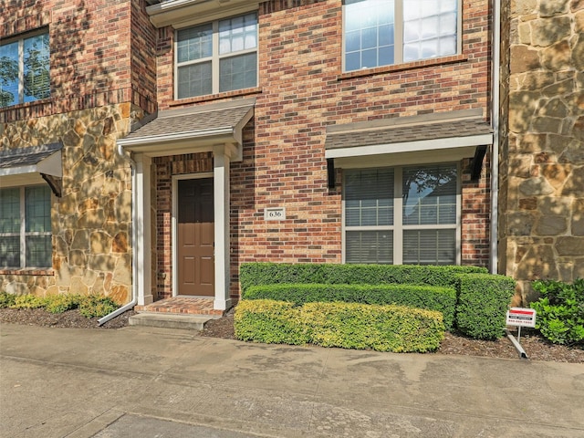 property entrance with brick siding and stone siding