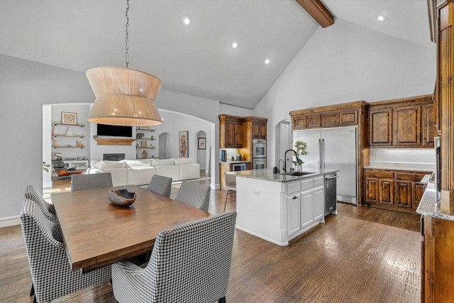 dining space featuring dark wood finished floors, recessed lighting, arched walkways, beam ceiling, and high vaulted ceiling