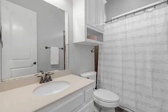 bathroom featuring a shower with shower curtain, toilet, and vanity