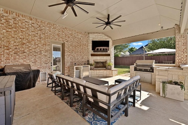 view of patio featuring fence, a ceiling fan, area for grilling, and an outdoor kitchen