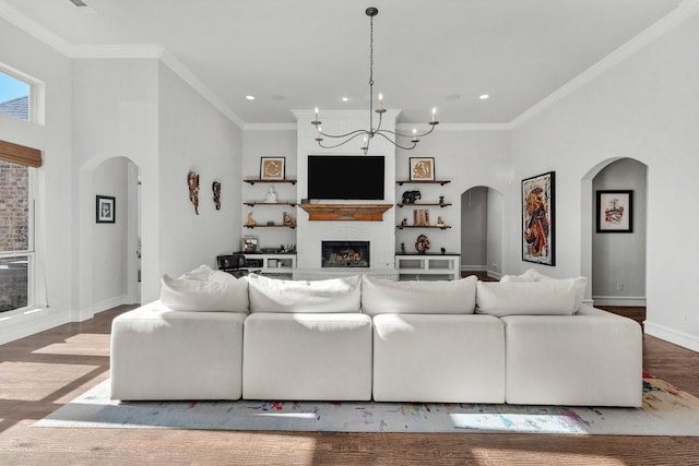 living room with a fireplace, baseboards, recessed lighting, and arched walkways