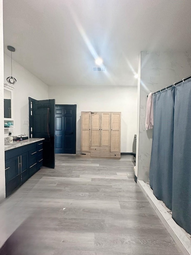interior space featuring pendant lighting, visible vents, light wood-type flooring, and light countertops