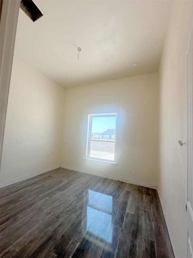 empty room featuring wood finished floors and baseboards