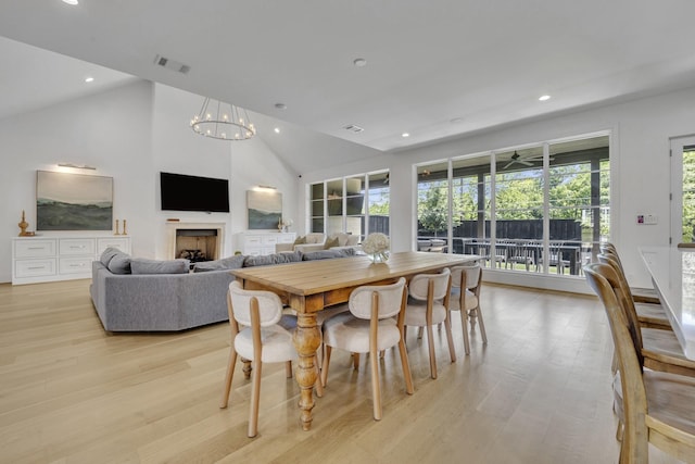 7141 Lyre Ln, Dallas, TX 75214 - dining area featuring recessed lighting, light wood-style flooring, a chandelier, a fireplace, and high vaulted ceiling
