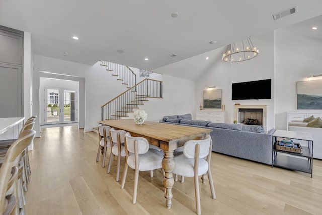 7141 Lyre Ln, Dallas, TX 75214 - dining space featuring light wood finished floors, a chandelier, stairway, recessed lighting, and a fireplace