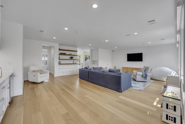 living area with visible vents, light wood finished floors, and recessed lighting