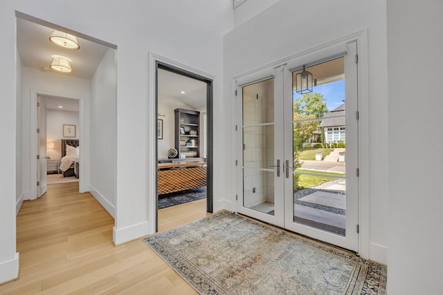 foyer entrance with baseboards and light wood-style floors