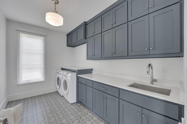 laundry area featuring a sink, cabinet space, independent washer and dryer, baseboards, and plenty of natural light