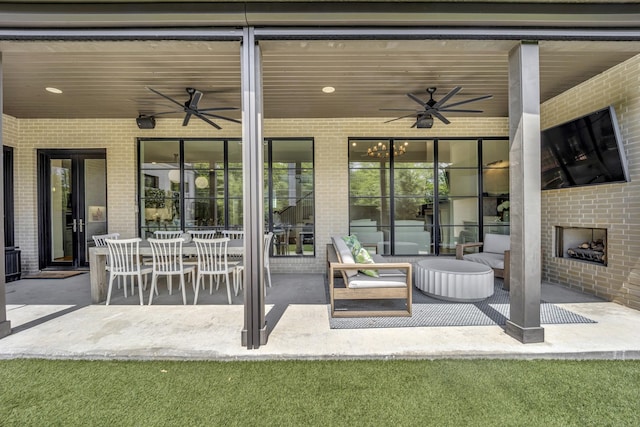 view of patio / terrace featuring ceiling fan and an outdoor brick fireplace