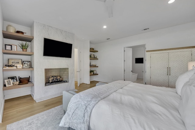 7141 Lyre Ln, Dallas, TX 75214 - bedroom with light wood-style flooring, a fireplace, and recessed lighting