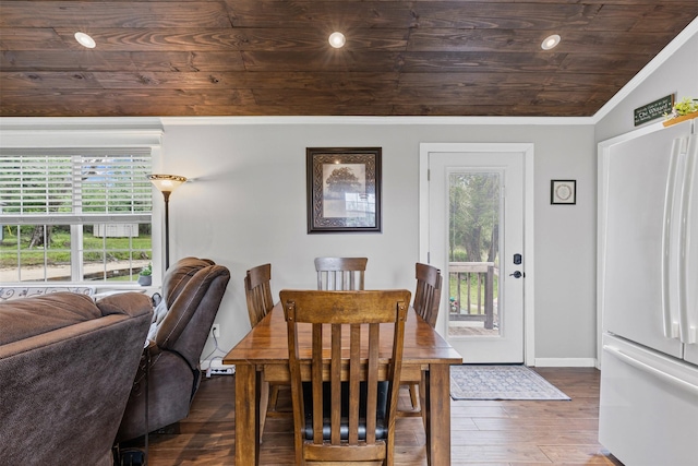 dining area with baseboards, ornamental molding, wood ceiling, and wood finished floors