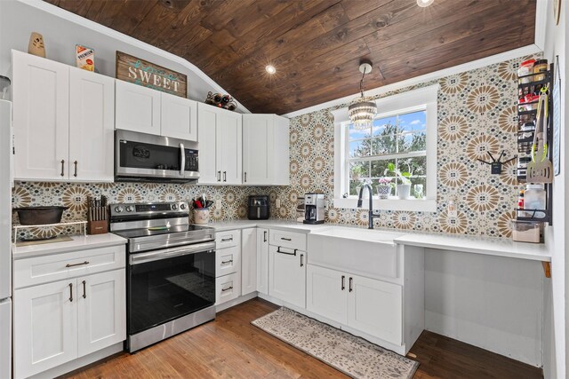 kitchen featuring wood ceiling, backsplash, appliances with stainless steel finishes, vaulted ceiling, and light countertops