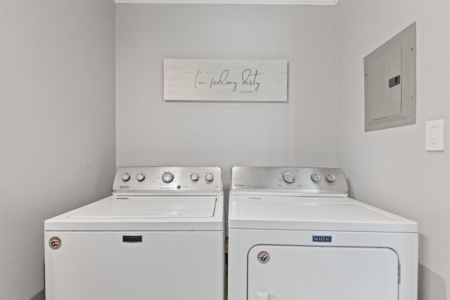washroom featuring electric panel, laundry area, and washing machine and clothes dryer