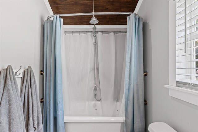 bathroom with toilet and shower / bath combo with shower curtain