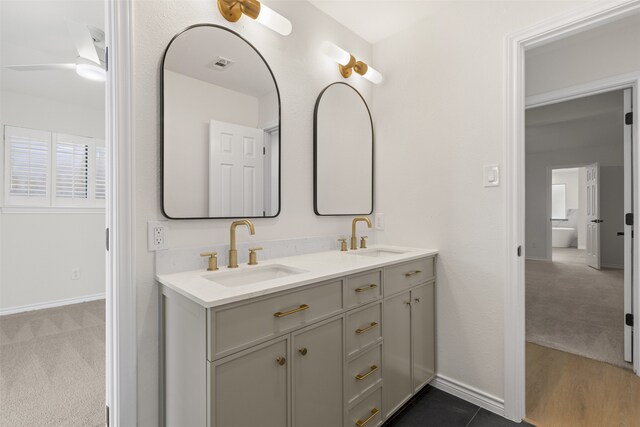 bathroom featuring double vanity, a sink, baseboards, and visible vents