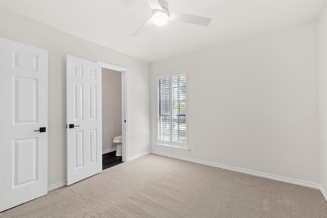 unfurnished bedroom featuring baseboards, ensuite bathroom, and carpet flooring