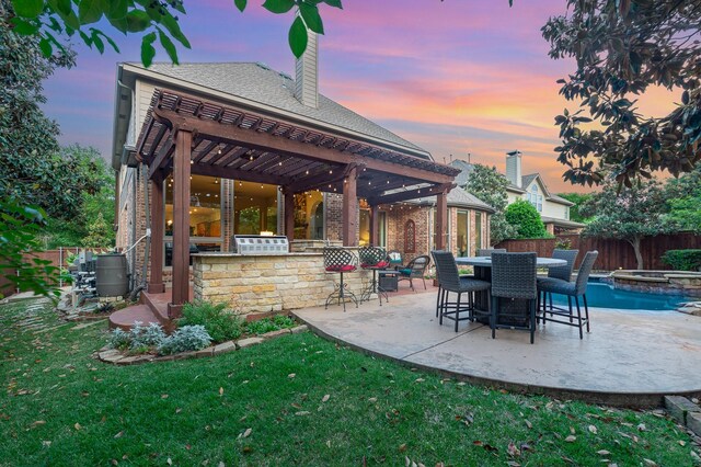 905 Maybach Ct, Mckinney, TX 75071 - patio terrace at dusk with fence, a pergola, outdoor dry bar, an outdoor kitchen, and a yard