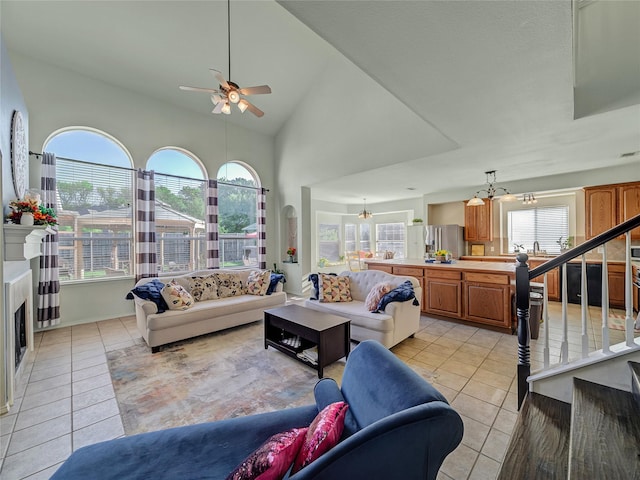 3115 Reagenea Dr, Wylie, TX 75098 - living room featuring stairs, light tile patterned floors, ceiling fan with notable chandelier, and a fireplace
