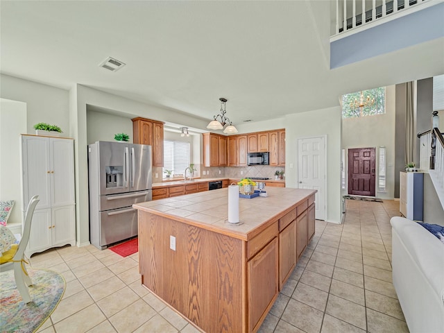 3115 Reagenea Dr, Wylie, TX 75098 - kitchen with visible vents, tile counters, light tile patterned floors, stainless steel fridge with ice dispenser, and backsplash